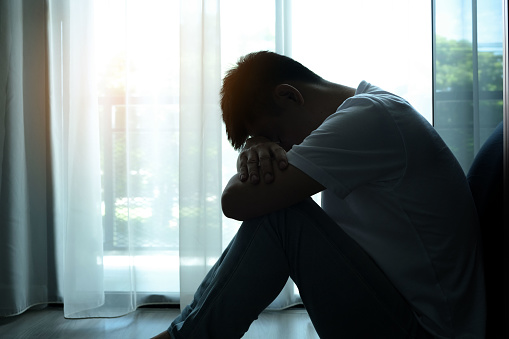 man sitting in the corner of the room have emotional and mental problems He has depression and stress from society and work. medical concept