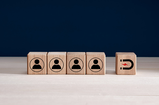 Inbound marketing strategy, customer retention, digital marketing and attracting potential customers in business concept. Wooden cubes with magnet icon attracts the customer icons.