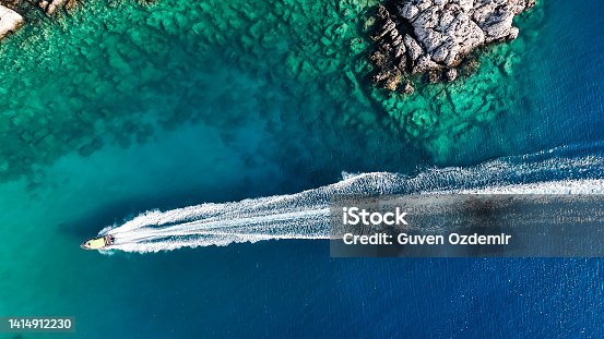 istock Luxury speed boat floating in open sea at summer, Yacht sailing in sea at hot summer day, Seashore of Mediterranean Sea at summer, Cruise speed boat floating in sea along rocky mountain coastline of Mediterranean Sea 1414912230