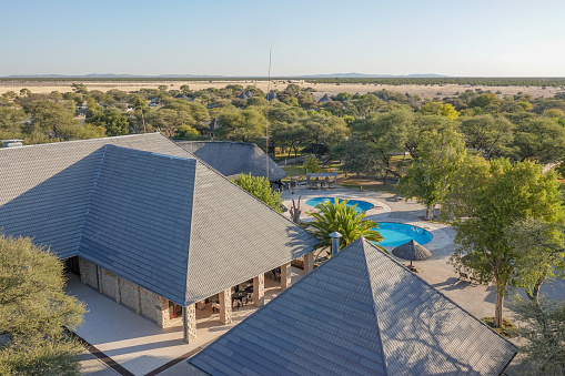 Swimming Pool at the government-owned Okaukuejo safari camp in Etosha National Park in Kunene Region, Namibia. This a government property. The image was taken from a free to enter tower called the Okaukuejo Tower. There is no fee to enter this tower, it is free of charge. The rest camp is in the national government park of Etosha.