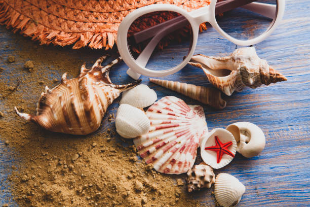 istock beach accessories glasses hat cockleshells on wood deck sand 1414914413