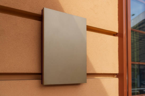 istock mockup for logo. square, empty, classic signboard against a yellow wall 1414915771