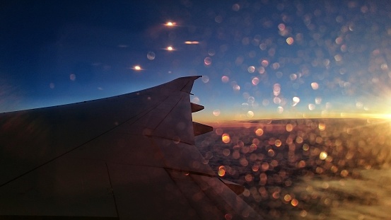 This photo was taken from the airplane window while in the sky at the border between sunrise and sunset