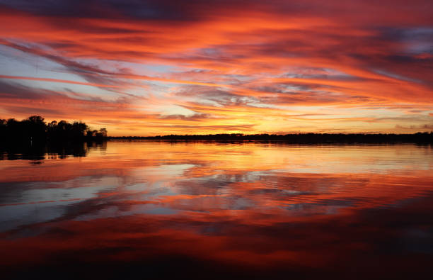 красный закат на точке - coral water sunset usa стоковые фото и изображения