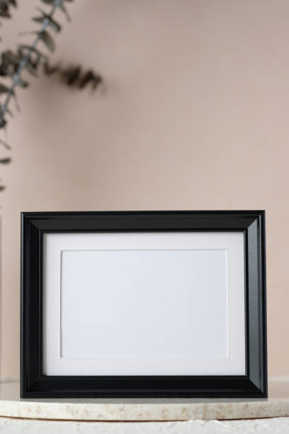 istock top view blank black photo frame mockup with eucalyptus brancch at peach wall 1414918429