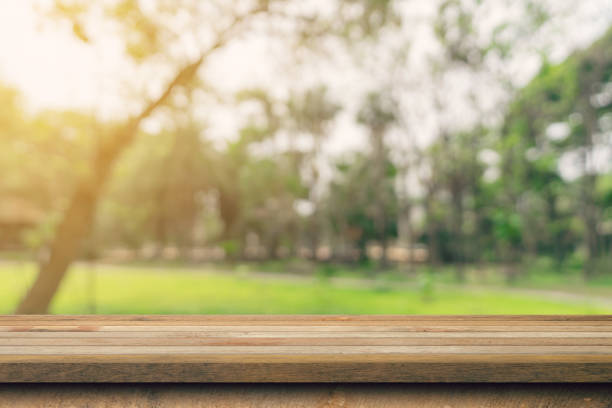 istock Empty wooden table top and green bokeh display montage for product with space. 1414919103