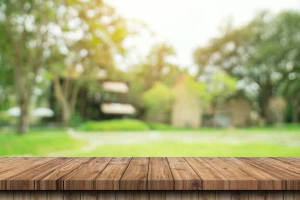 istock Empty wooden table top and green bokeh display montage for product with space. 1414919122