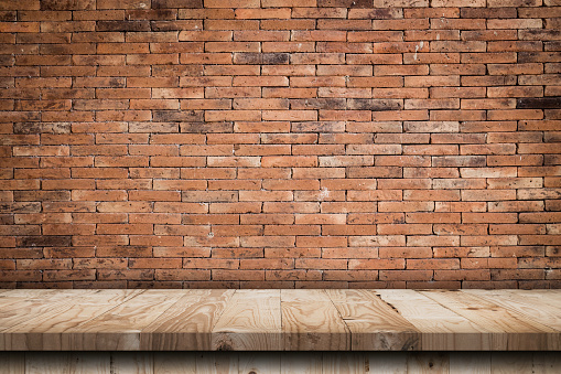 Empty wooden table top and red brick wall and rough crack background texture