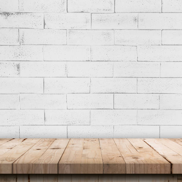 istock Empty wooden table top and white brick wall and rough crack background texture 1414919162