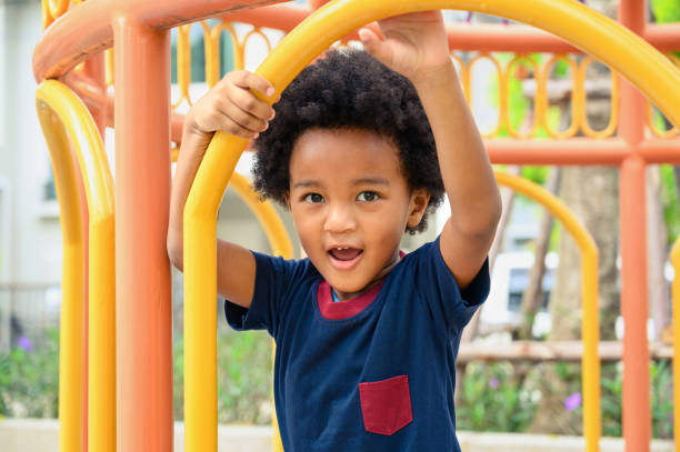 istock Cute African American boy having fun while playing on the playground on sunny day. Five years old. Outdoor activity. 1414920495