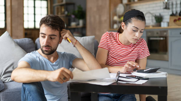 Frustrated concerned young couple calculating overspend budget, doing paperwork job at laptop, talking about financial problems, insurance, mortgage, fees, loan conditions, bankruptcy, economic inflation Frustrated concerned young couple calculating overspend budget, doing paperwork job at laptop, talking about financial problems, insurance, mortgage, fees, loan conditions, bankruptcy, economic inflation over spend stock pictures, royalty-free photos & images