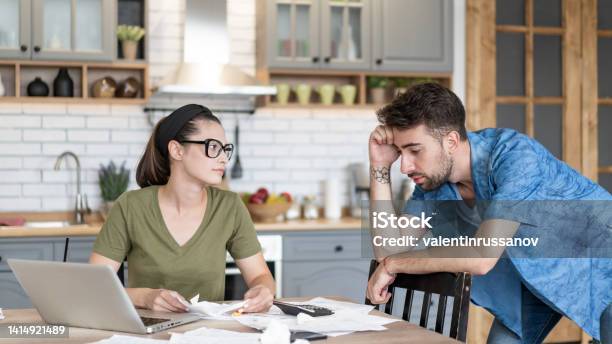 Frustrated Concerned Young Couple Calculating Overspend Budget Doing Paperwork Job At Laptop Talking About Financial Problems Insurance Mortgage Fees Loan Conditions Bankruptcy Economic Inflation Stock Photo - Download Image Now