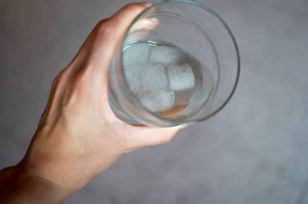 istock Hand holds a fresh glass of water 1414921986