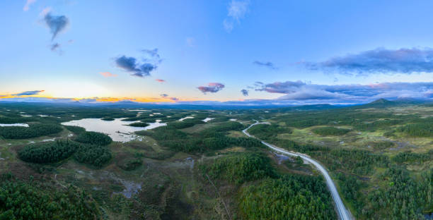 istock Road through green mountain and lake landscape 1414922080