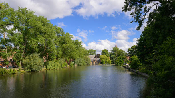Brugge, Belgium - July 4, 2022: Old canal (Minnewater) with trees and houses in Bruges