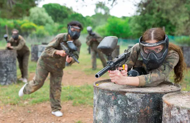 Photo of Portrait of girl in camouflage on paintball field