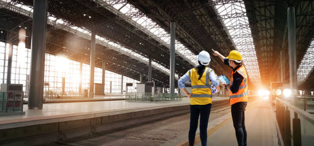 équipe d’ingénieurs techniciens vérifie et analyse un projet de construction de gare inachevé avec logiciel et plan, conception et planification de la construction, travail d’équipe. - transport ferroviaire photos et images de collection