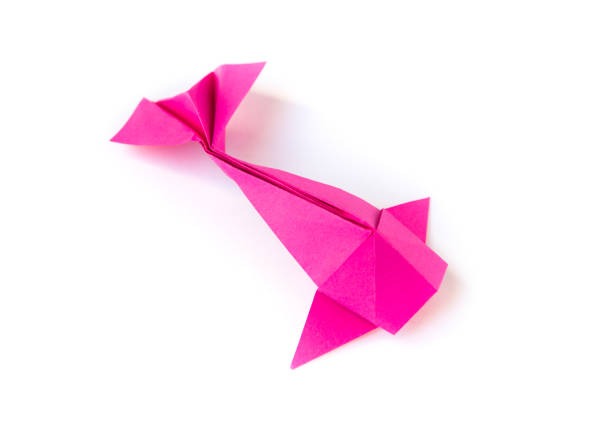 istock Pink paper fish origami isolated on a white background 1414925708