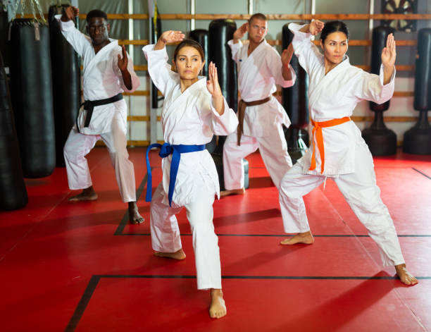 istock Adult people practicing taekwondo and warming up for training while standing barefoot 1414925979