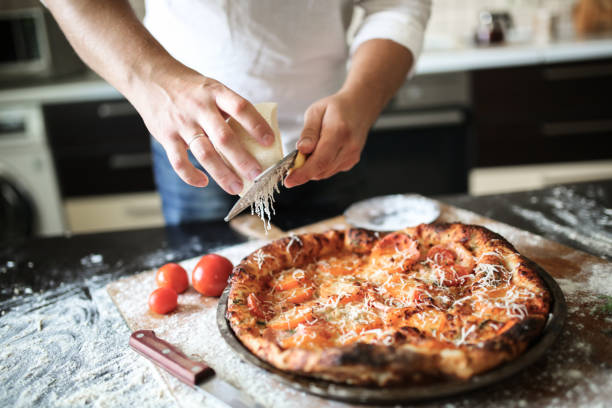 istock male hands rubbed cheese grated on pizza in home 1414927083
