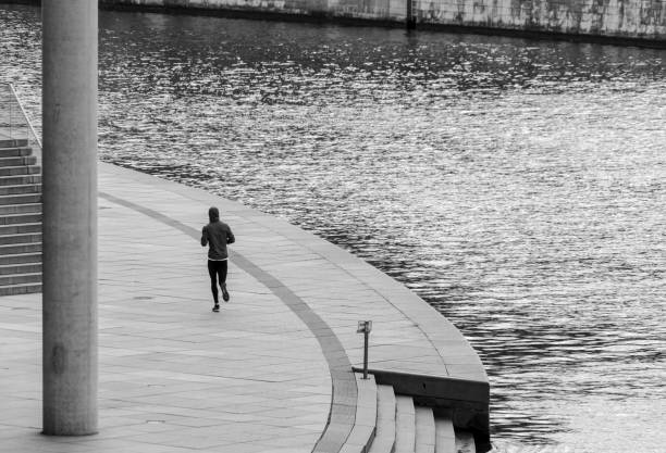 istock Rear View Of Man Walking On Footpath By Lake 1414931126