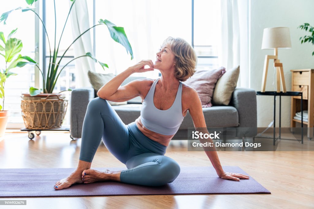 Beautiful mature senior woman at home Beautiful mature senior woman at home, domestic life and leisure moments - 50-60 years old pretty female adult training in the living room Women Stock Photo