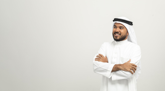 Portrait of arabic man with kandura dress on isolated white background. Arab business people thinking.