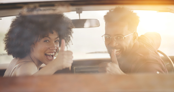 Smiling, carefree and happy couple on road trip getaway enjoying freedom in summer, thumbs up enjoying freedom in summer feeling excited. Cheerful and joyful male and female having a good vacation