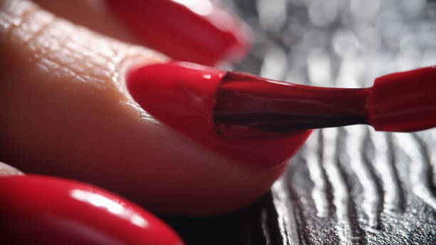 istock Red nail polish is applied to hand closeup 1414942510