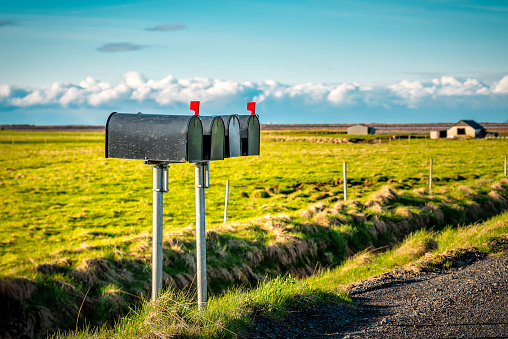 Black metal mailboxes along a quiet country road