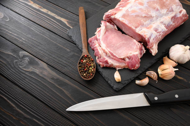 istock A large piece of pork loin on a rustic dark background. 1414943883