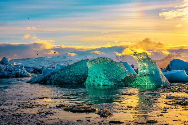 paesaggio incredibile con iceberg nella laguna glaciale di jokulsarlon. parco nazionale del vatnajokull, islanda sud-orientale, europa. - green sky water wave foto e immagini stock