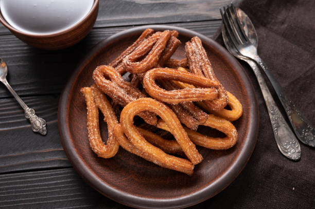 istock Homemade churros with chocolate on a dark wooden rustic background. 1414944464