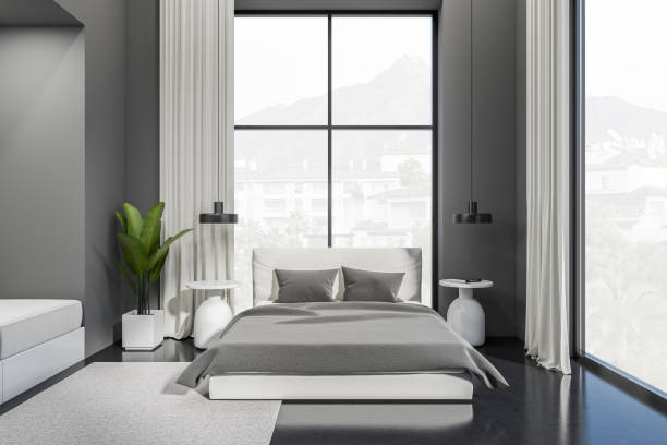 istock Grey bedroom interior with bed and nightstand near panoramic window 1414945139