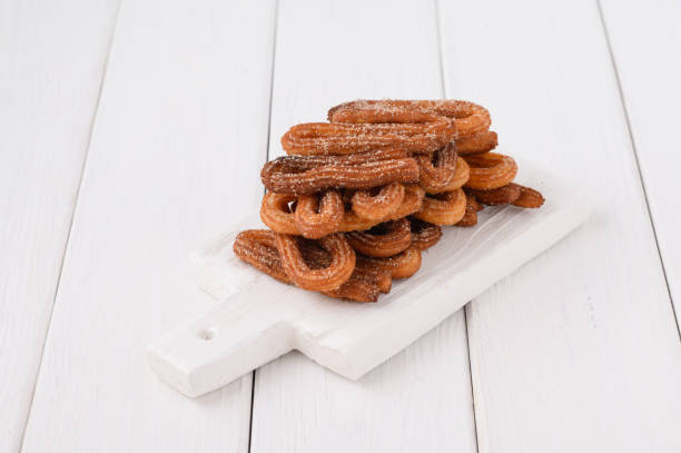 istock Homemade churros on a white wooden background. 1414945295