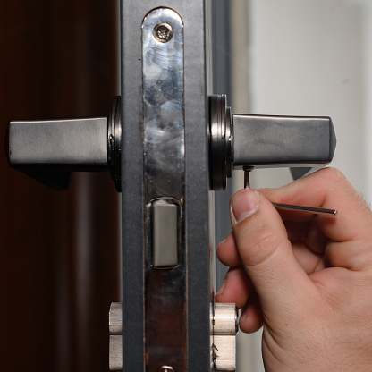 Hex key and installation of door lock and handle, close-up installation work, interior door.