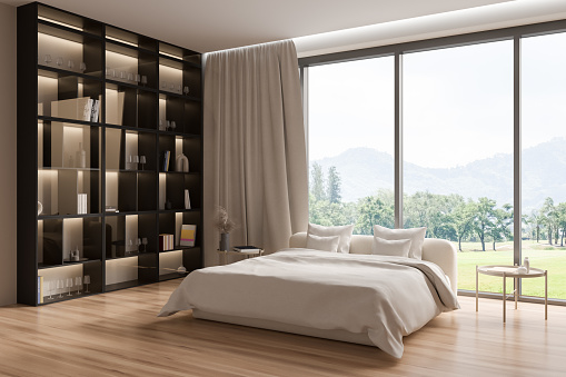 Light bedroom interior bed and shelf with glasses and decoration, side view, hardwood floor. Panoramic window on countryside. Stylish hotel studio apartment. 3D rendering