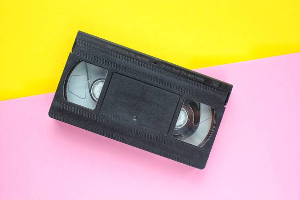 istock Black VHS videotape cassette on yellow and pink background 1414947685