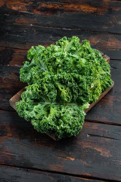 istock Green kale salad leaf, on old dark  wooden table background 1414947908