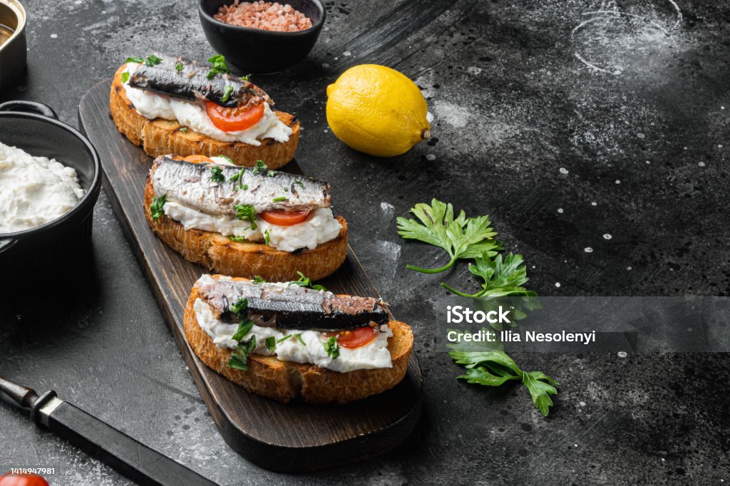 Fish And Ricotta Crostini With Fish And Ricotta On Black Dark Stone Table Background ...