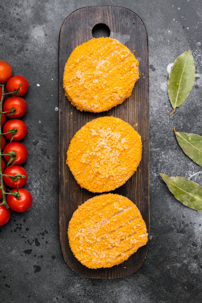 istock Raw fishcake Breaded, on black dark stone table background, top view flat lay 1414948102