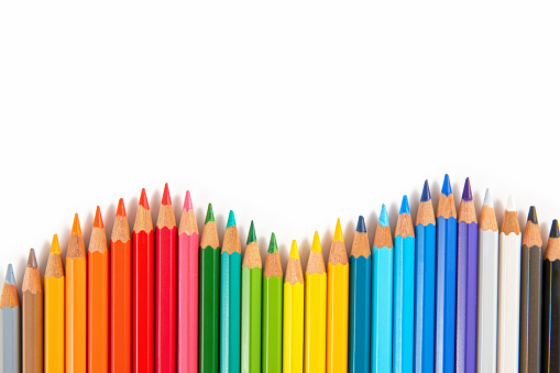 Crayons and pastels lined up isolated on white background for banner