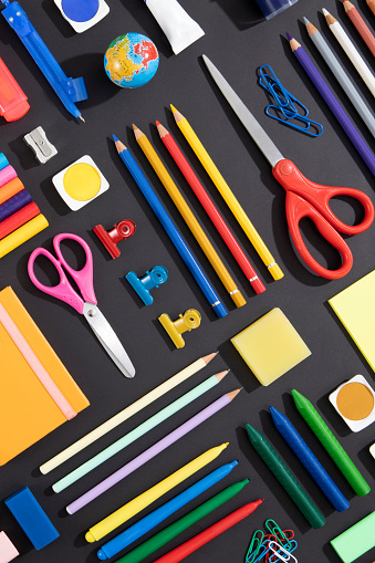 Back to school concept with school supplies knolling on black background