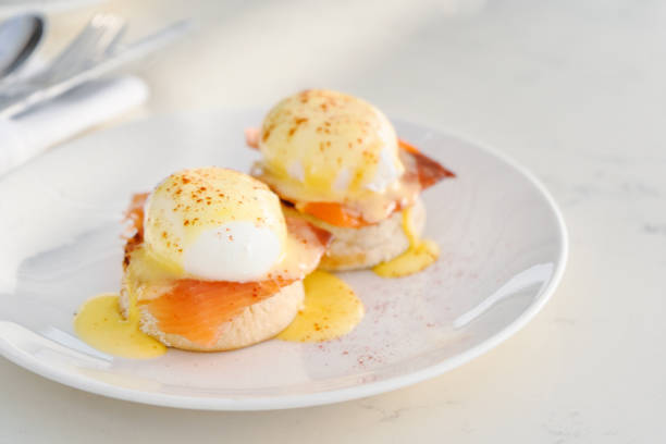 Eggs Benedict served on English muffin with salmon and Hollandaise sauce