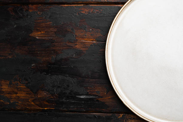 istock White rustic ceramic plate with copy space for text or food with copy space for text or food, top view flat lay , on old dark  wooden table background 1414952784