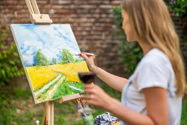 Woman  painting and drinking wine stock photo