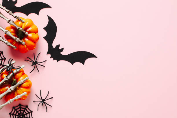 istock Halloween flat lay composition with orange pumpkins, spiders, bats on pastel pink background. Happy Halloween banner mockup. 1414953921