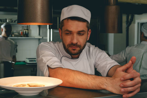istock Tired chef on kitchen restaurant waiting for a new order and looking on ready dish 1414954715