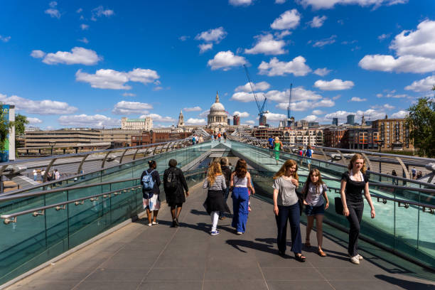 london united kingdom millenium bridge mit vielen fußgängern an einem sonnigen tag - millennium footbridge stock-fotos und bilder
