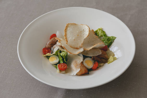 Caesar salad with roasted chicken breast, croutons, cherry tomatoes and parmesan on white plate Caesar salad with chicken breast, croutons, cherry tomatoes and parmesan on white restaurant plate caesar grunt photos stock pictures, royalty-free photos & images